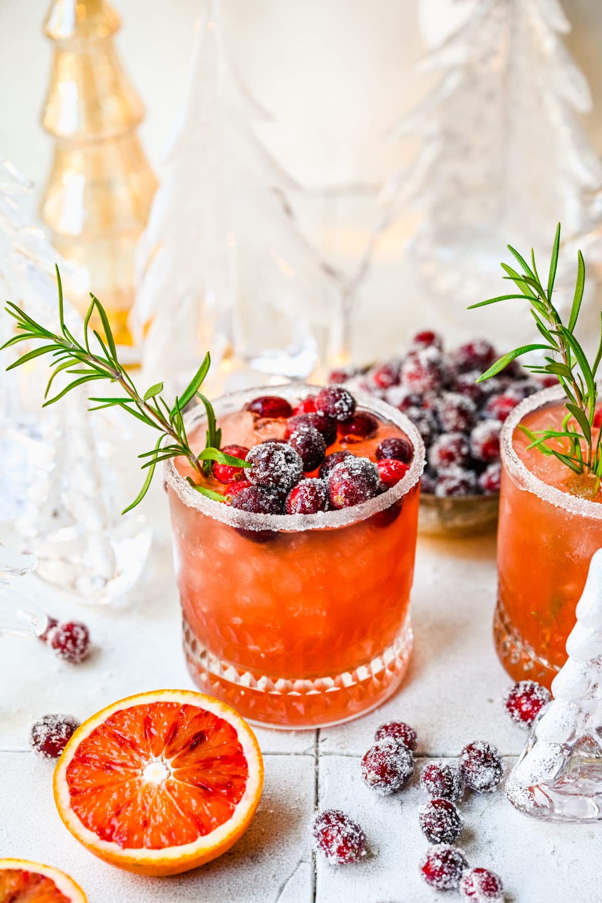 Front view of mistletoe margarita garnished with rosemary and sugared cranberries.