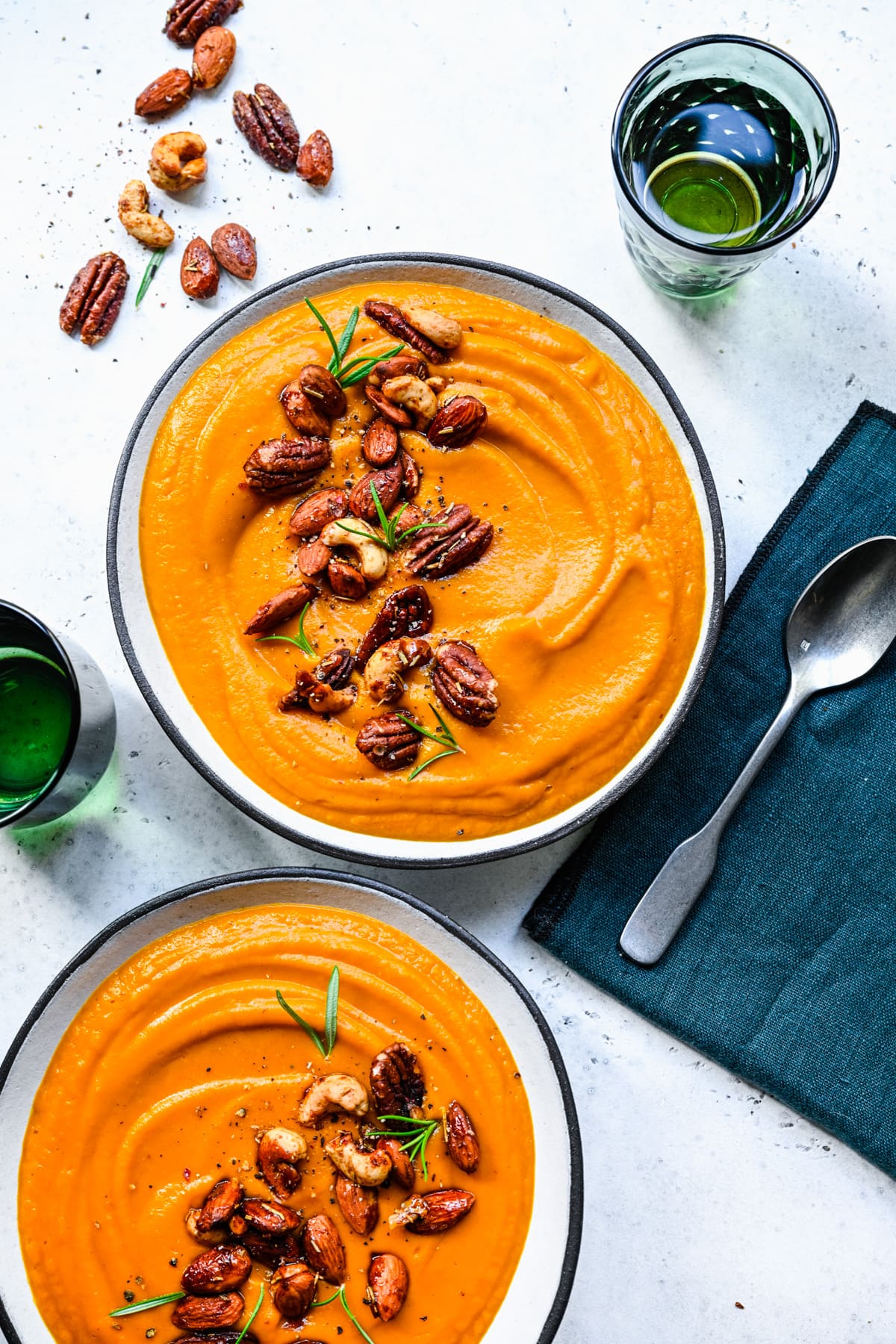 Finished pumpkin sweet potato soup in bowls and topped with nuts.