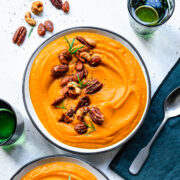 Close up of the finished pumpkin sweet potato soup in a bowl topped with nuts.