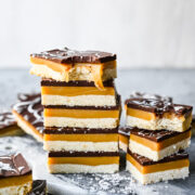 Finished millionaire shortbread bars in a stack to see layers.