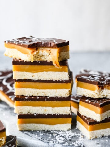 Finished millionaire shortbread bars in a stack to see layers.