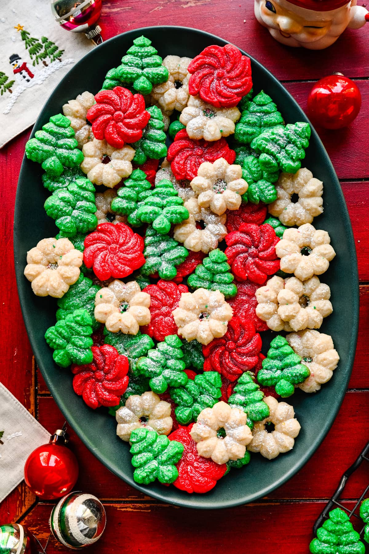 Overhead of the finished vegan spritz cookies on a green platter.