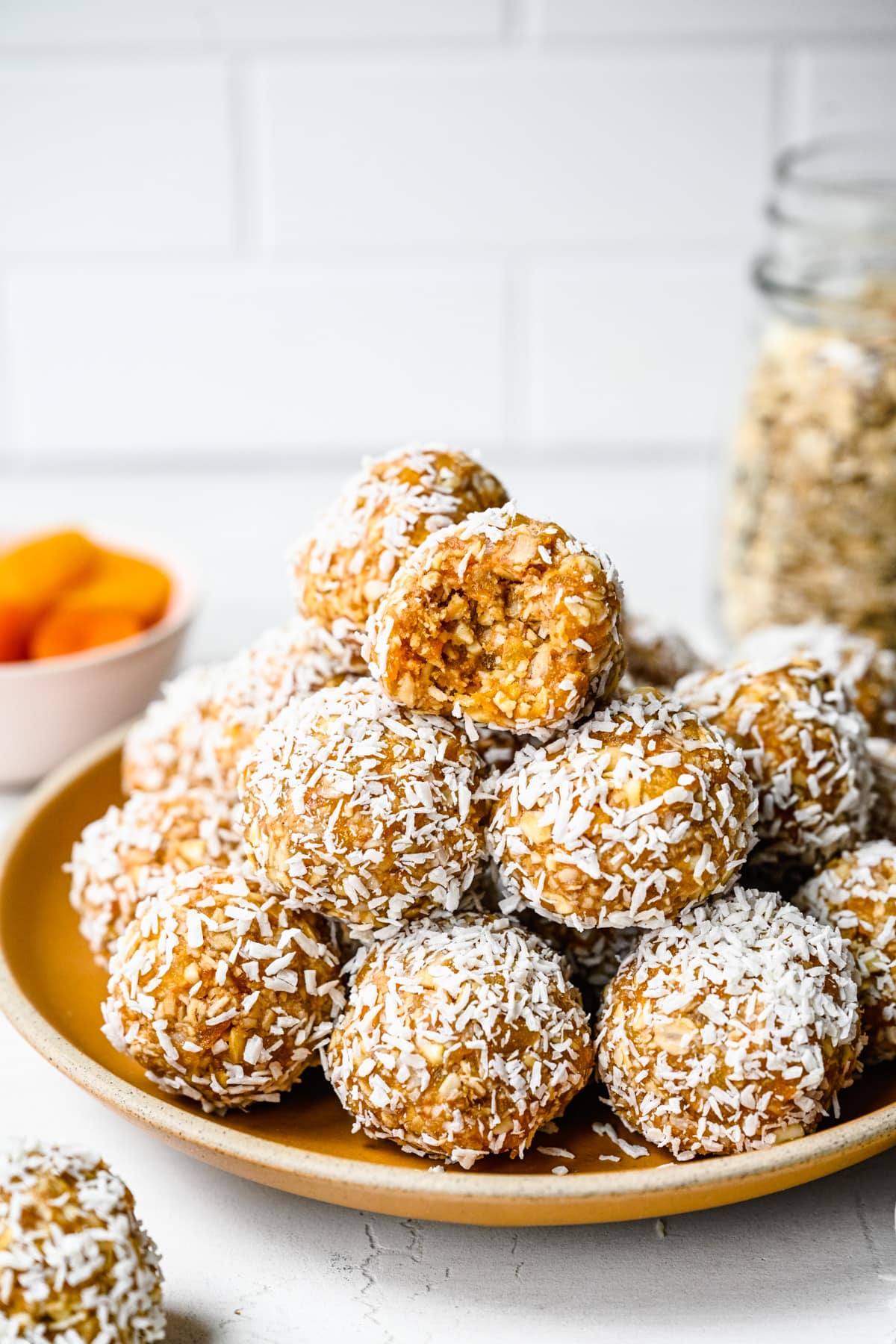 Finished apricot bliss balls on an orange plate.