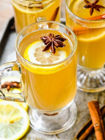 Close up overhead of the finished hot toddy cocktails in glass mugs.