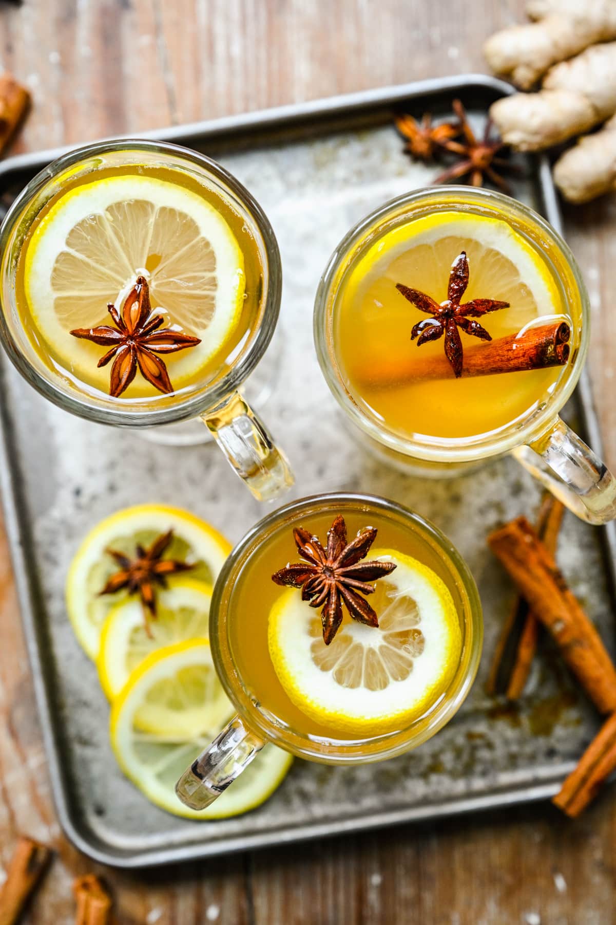 Full overhead of the hot toddy cocktails with spices and lemon on top.