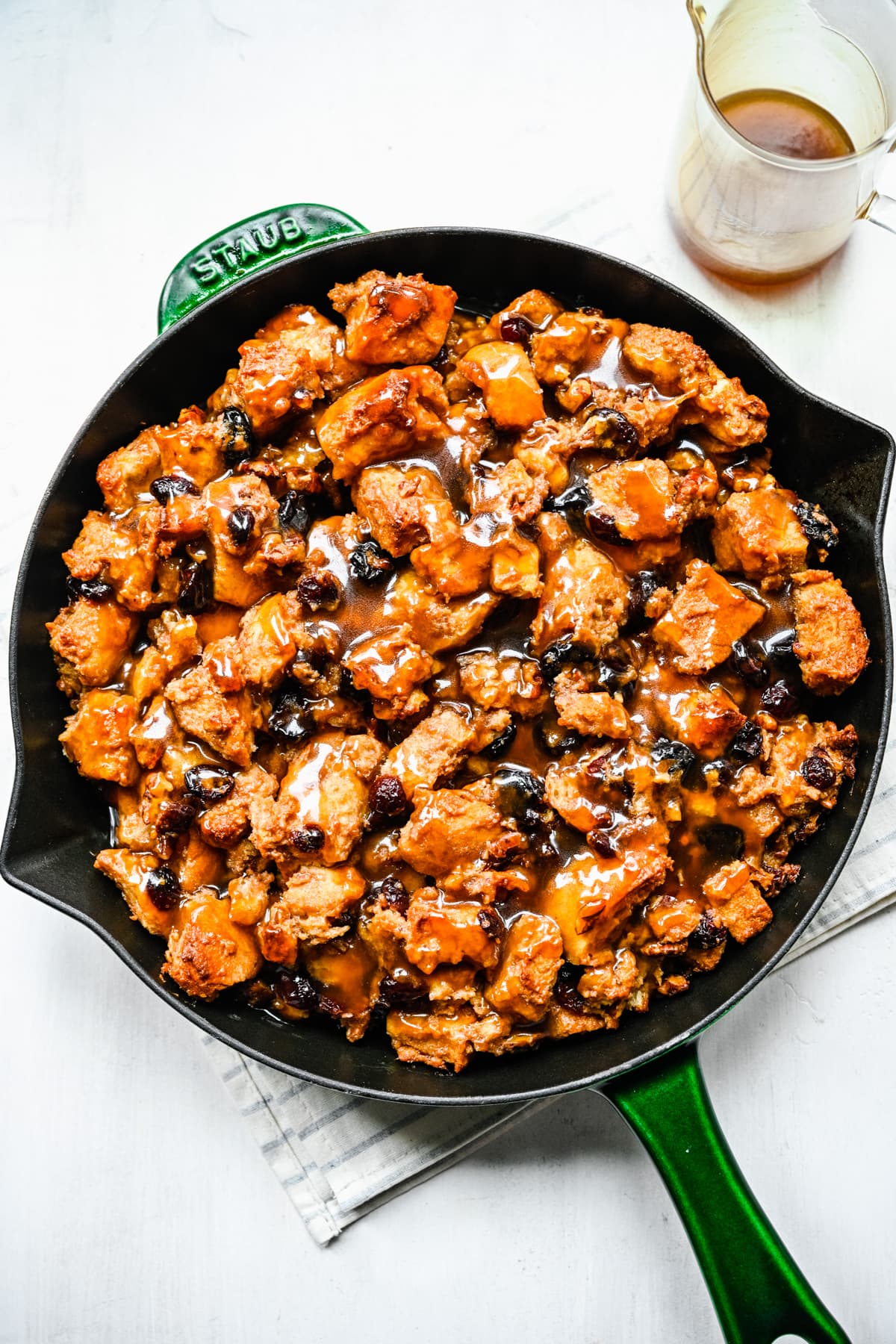 Overhead of the finished bread pudding in a green skillet.