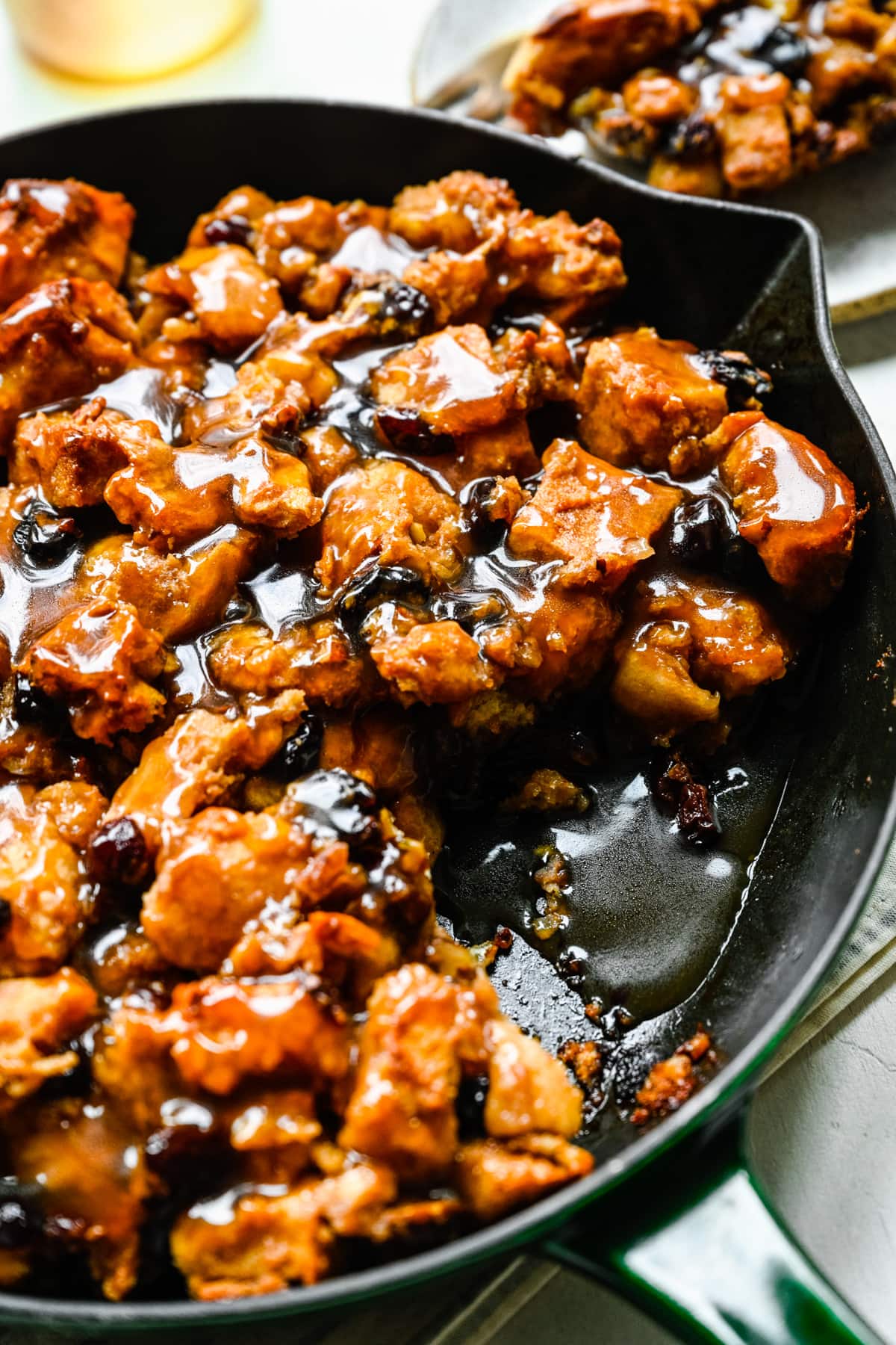 Close up view of bread pudding in skillet with a slice taken out.