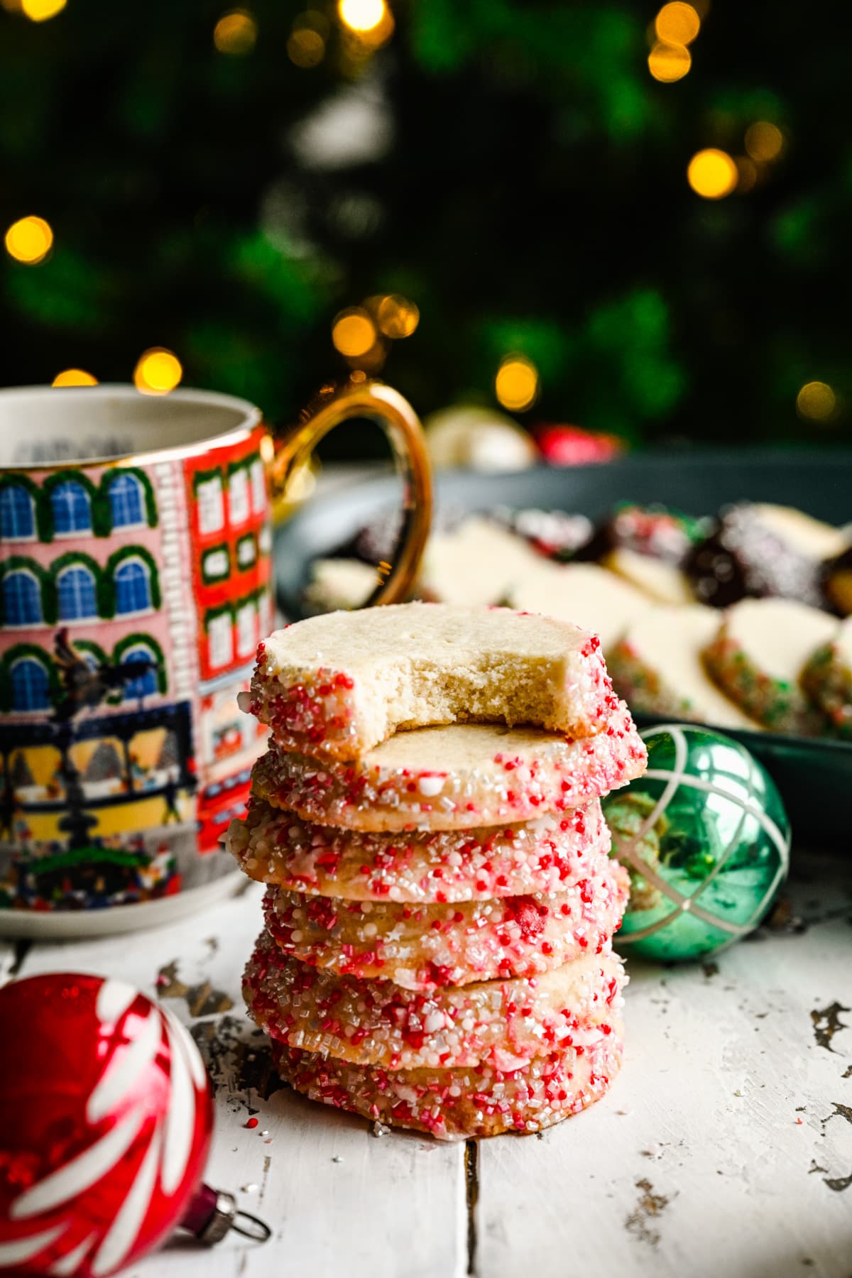 Side view of a stack of vegan butter cookies styled in front of christmas tree.