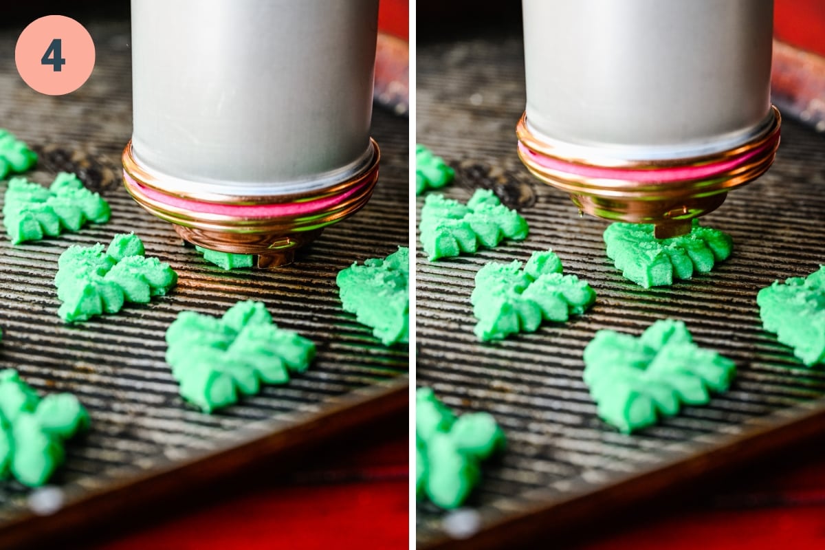 Using a cookie press to pipe tree-shaped cookies onto baking sheet.