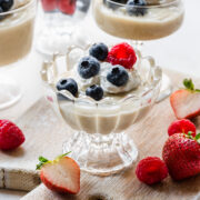 Finished vegan vanilla pudding in a glass topped with berries.