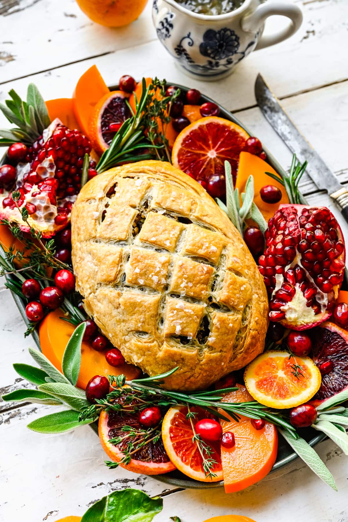 Finished vegan wellington on a platter with herbs and fruits.