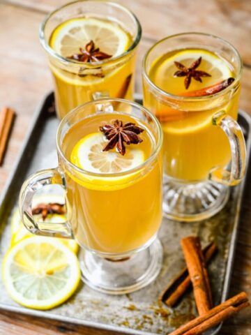 Overhead view of the finished hot toddy cocktails with lemon slices on top.