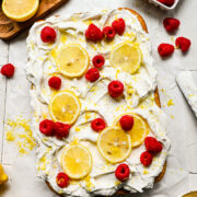 Finished vegan lemon cake topped with lemon slices and raspberries.