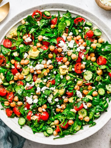 Overhead of the finished spinach chickpea salad in a white bowl.