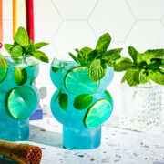 Finished blue mojitos in bubble shaped glasses.