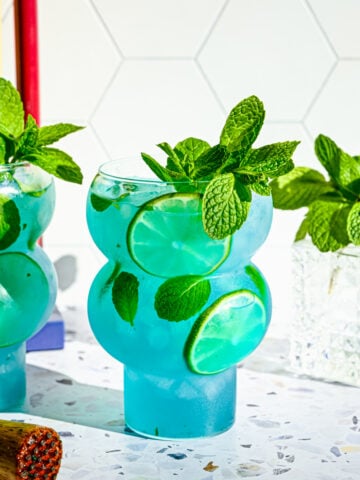 Finished blue mojitos in bubble shaped glasses.