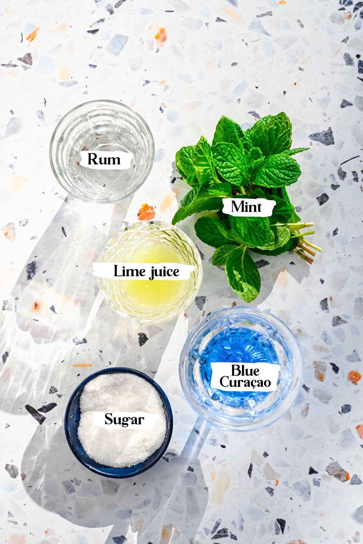 Blue mojito ingredients including mint and rum.