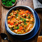 Overhead of the finished butter bean stew in a blue bowl.