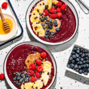 Close up of the finished chocolate acai bowls with fresh fruit on top.