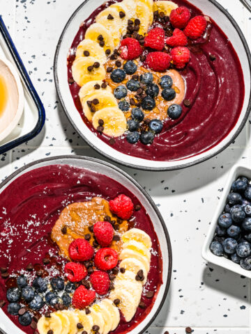 Close up of the finished chocolate acai bowls with fresh fruit on top.