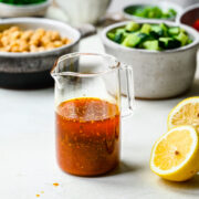 Harissa vinaigrette in a glass pouring dish.