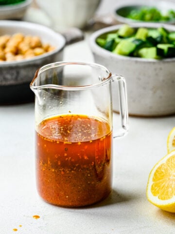 Harissa vinaigrette in a glass pouring dish.