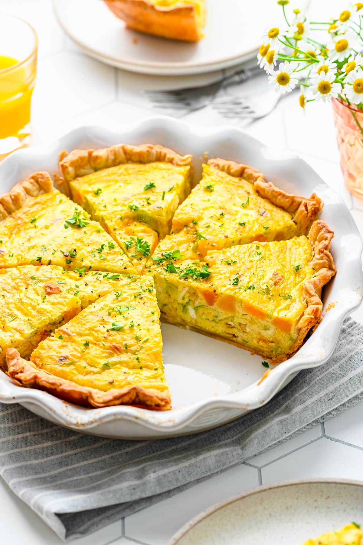 Overhead view of leek and squash quiche cut into slices.