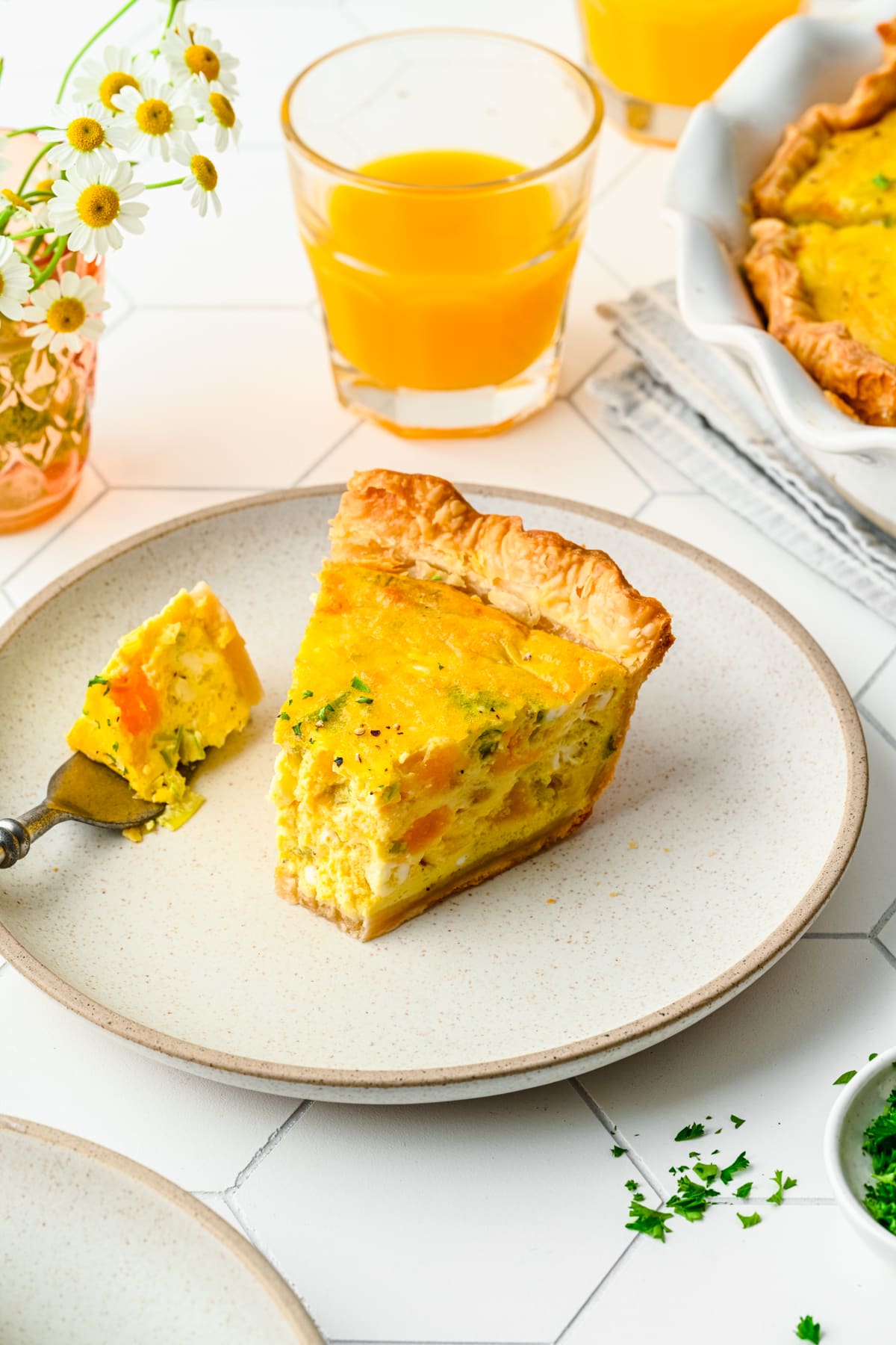 Overhead view of leek and squash quiche with a forkful taken out.