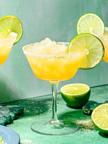 Finished rum margaritas with lime slice garnish.