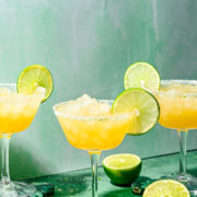 Finished rum margaritas in glasses with lime garnish and salt rim.