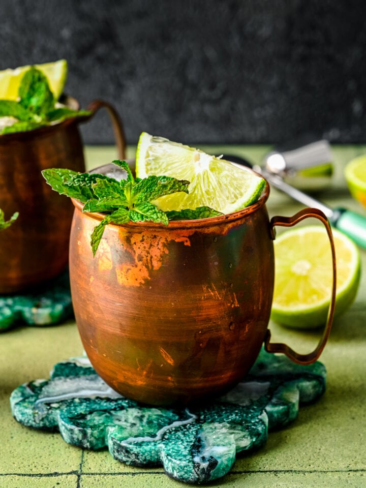 Finished rum moscow mules in copper mugs with lime and mint garnish.