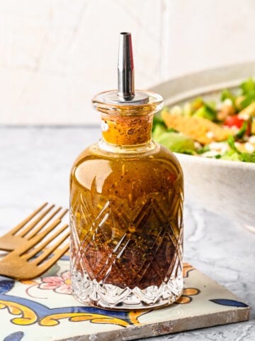 Finished sumac dressing in a glass bottle.