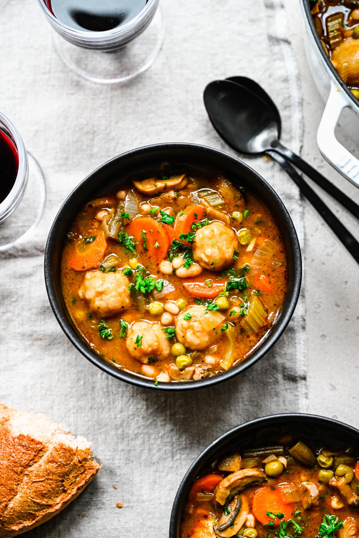 Overhead of the finished stew with dumplings in a black bowl.