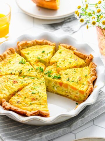 Overhead view of leek and squash quiche cut into slices.