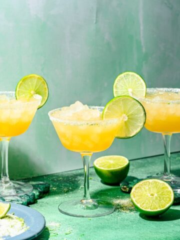 Finished rum margaritas in glasses with lime garnish and salt rim.