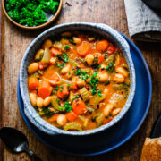 Finished butter bean stew in a blue bowl.