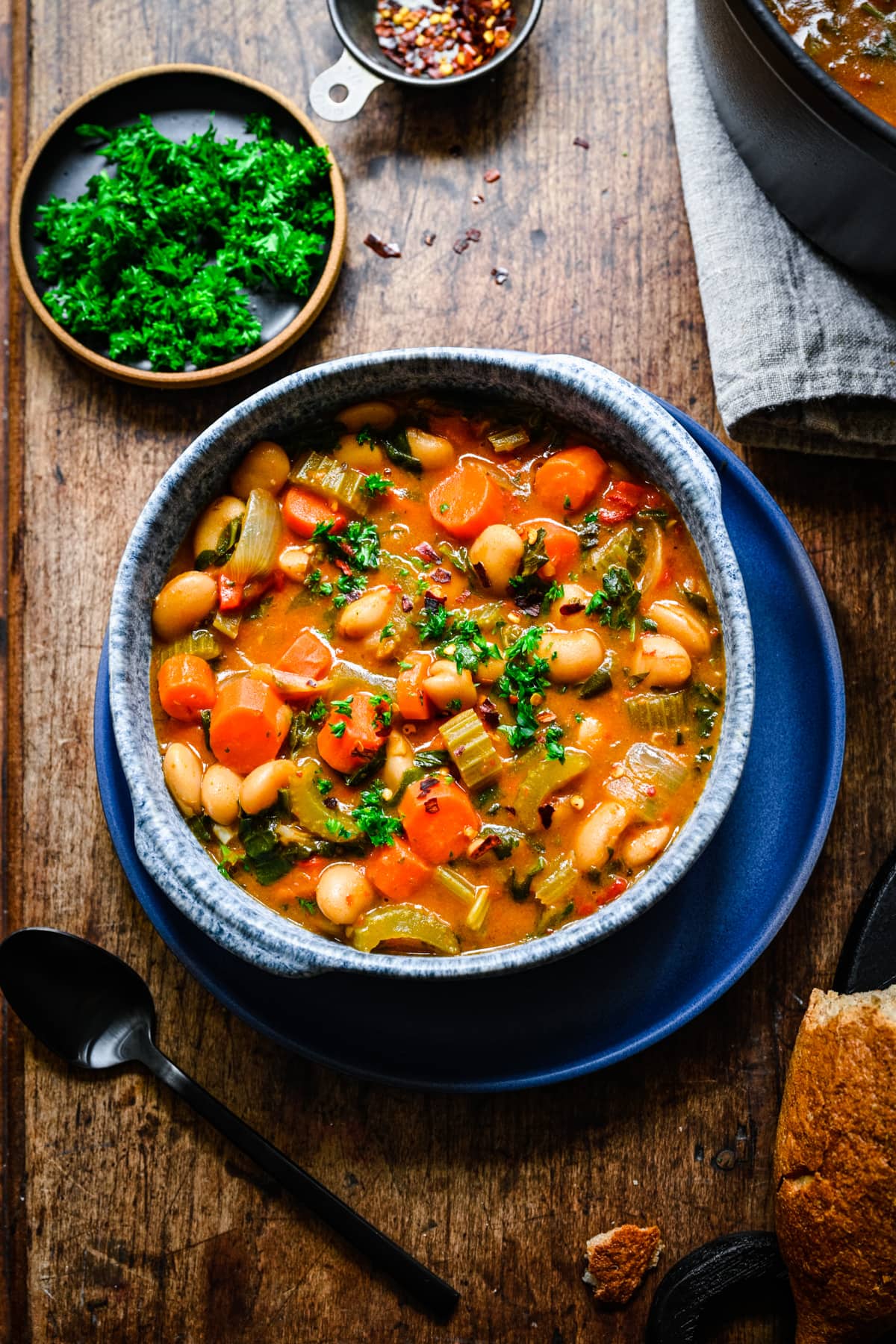 Finished butter bean stew in a blue bowl.