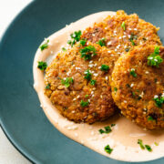 Overhead view of chickpea fritters on a green plate garnished with parsley.