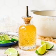 Finished lime simple syrup in a glass bottle.