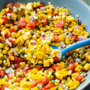 Spoon scooping the mango corn salsa out of the bowl.