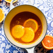 Overhead of the orange simple syrup in a saucepan with orange slices in it.