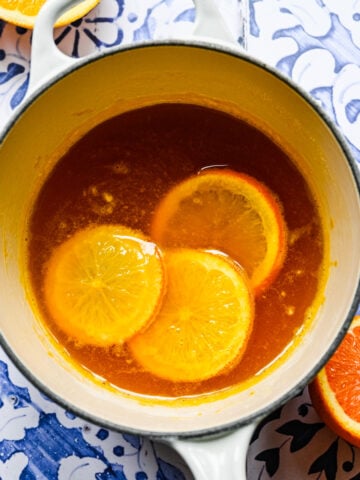 Overhead of the orange simple syrup in a saucepan with orange slices in it.