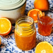 Finished orange simple syrup in a glass jar.