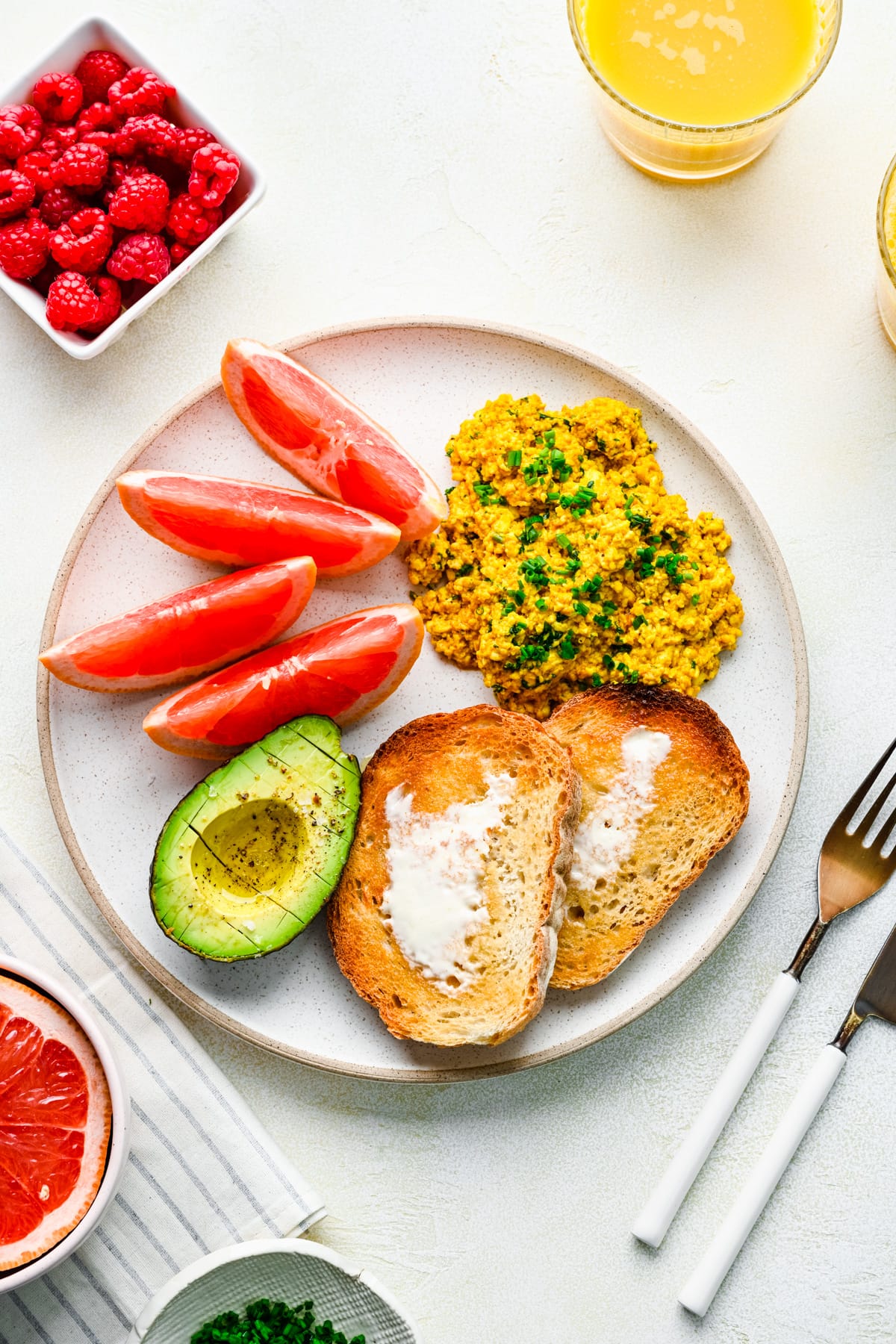 Overhead of the finished silken tofu scramble on a plate with other breakfast foods.