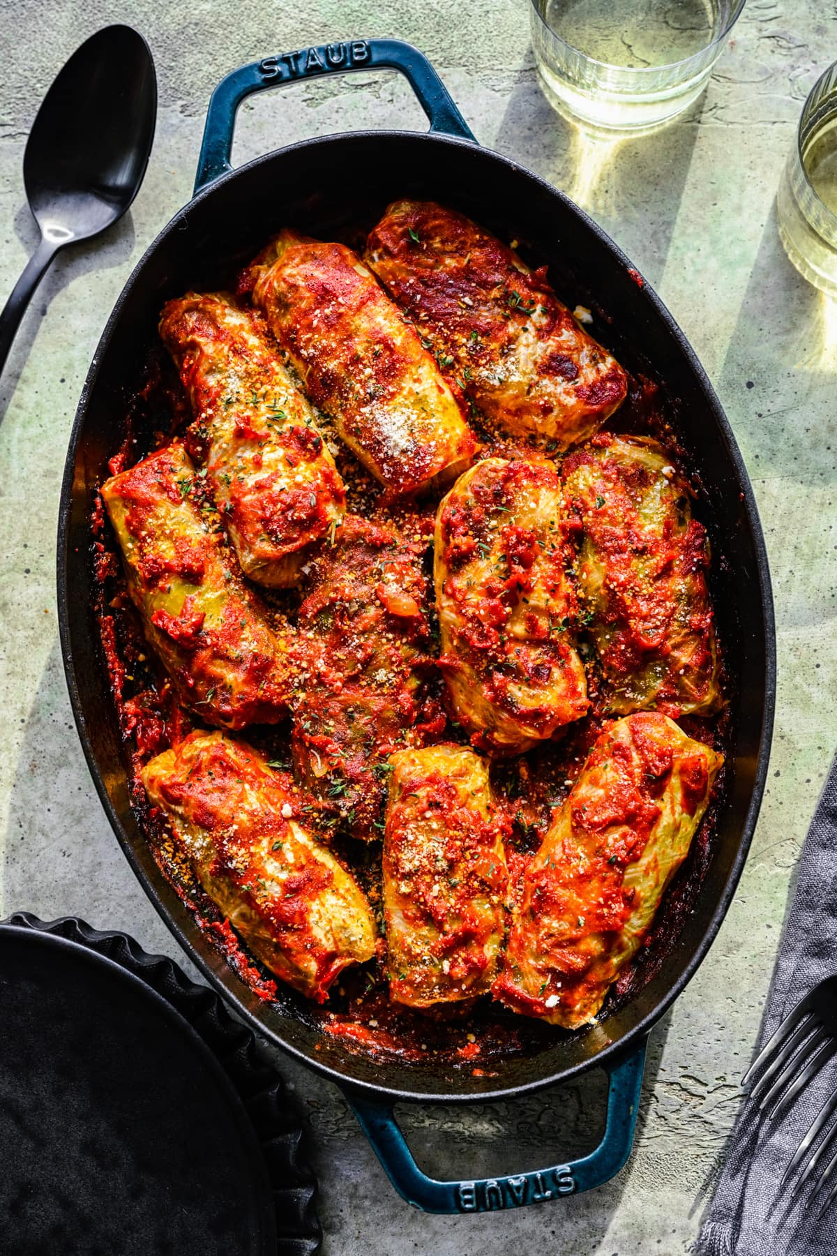 Overhead of the finished vegan cabbage rolls in a blue baking dish.