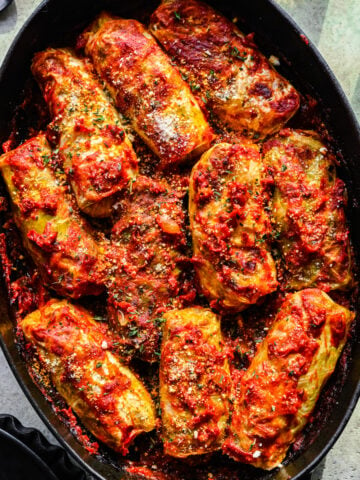 Close up overhead of the finished vegan cabbage rolls in a baking dish.