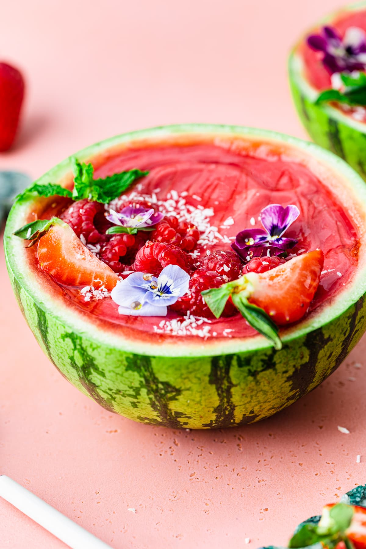 Side view of the finished watermelon smoothie bowls in a watermelon bowl.