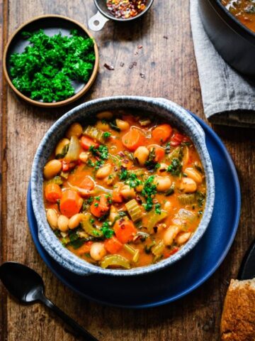Finished butter bean stew in a blue bowl.