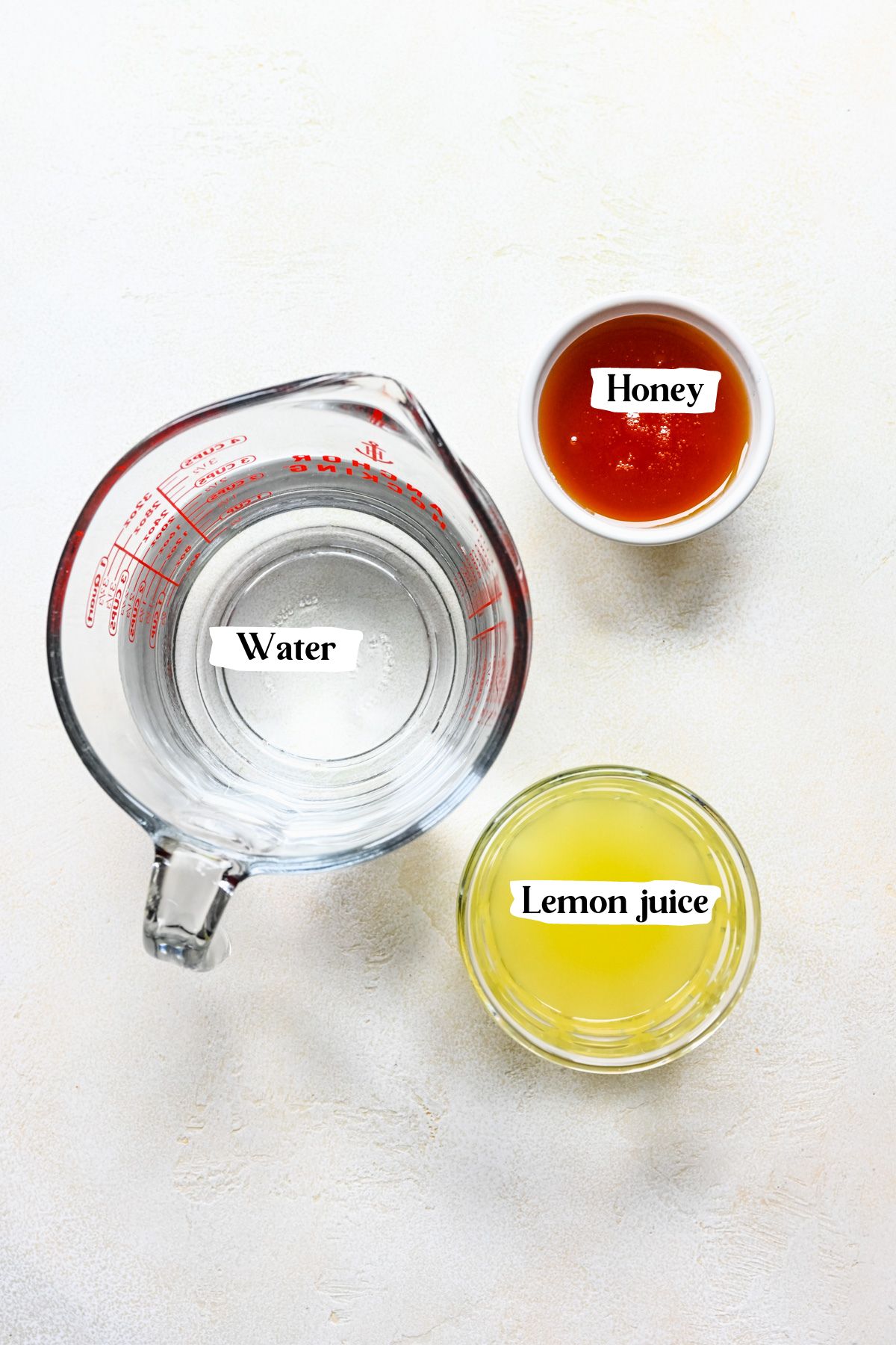 Overhead of the lemon popsicle ingredients including water and honey.