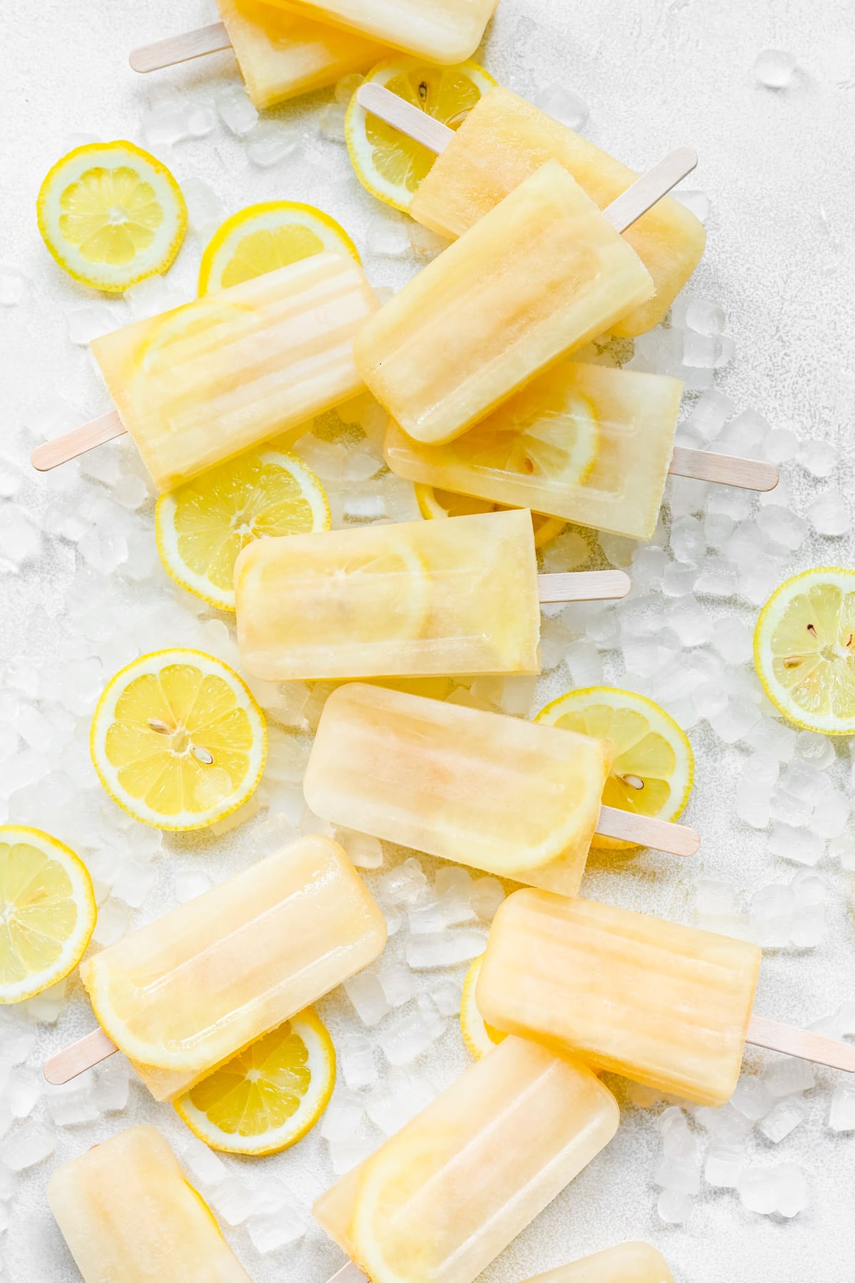 Finished lemon popsicles on top of ice and lemon slices.